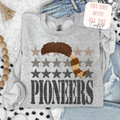 Gray sweatshirt with star pattern and 'Pioneers' text, displayed on a hanger with jeans and decorative items.