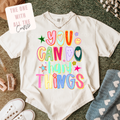 White t-shirt with colorful text 'You can do hard things' on a textured surface.