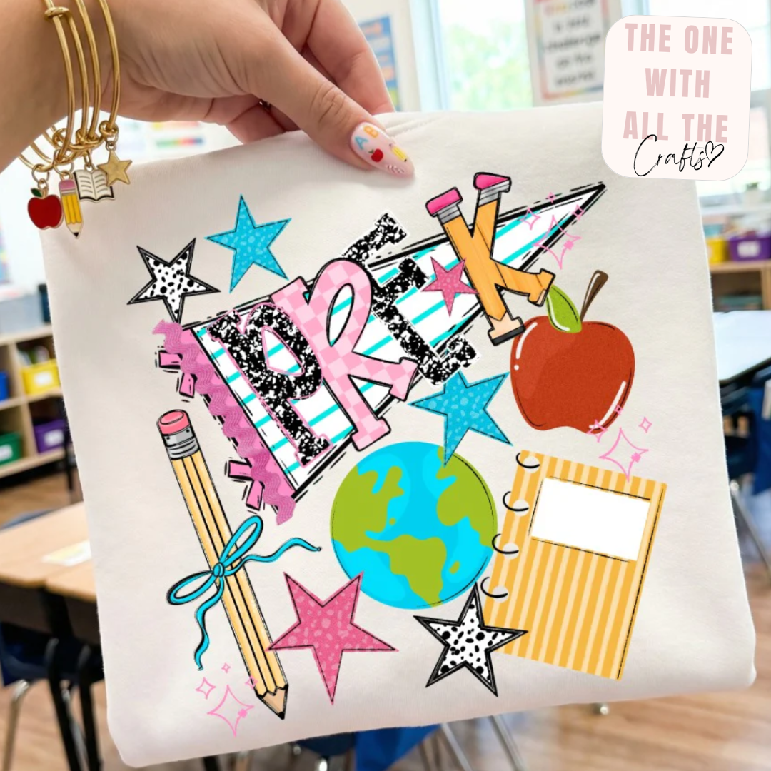Hand holding a tshirt with colorful school-themed designs in a classroom setting.