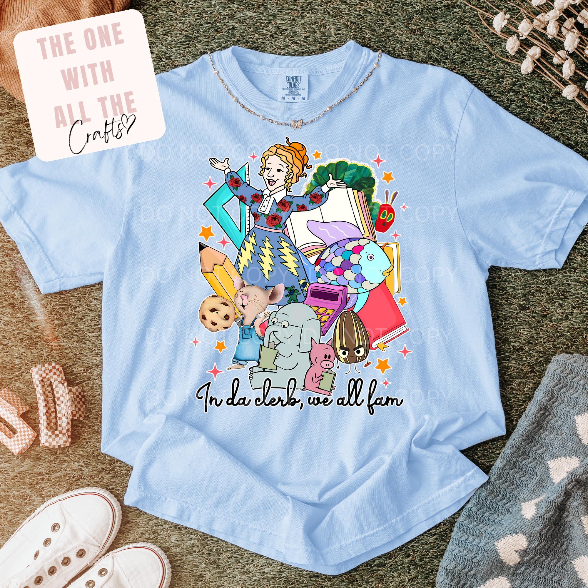 Light blue t-shirt with colorful graphic design on a textured surface