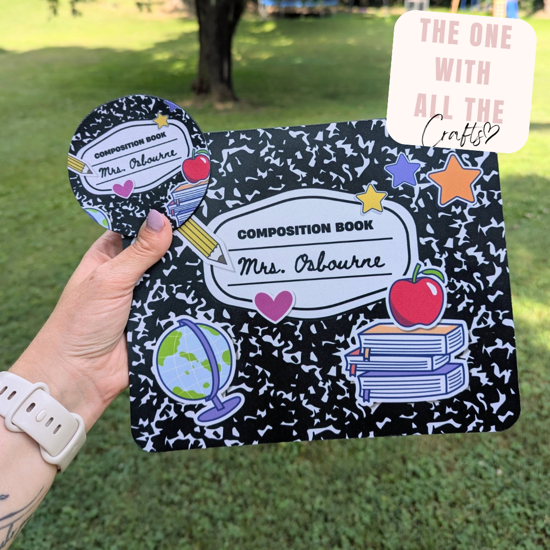 Composition book with decorative stickers held by a hand outdoors
